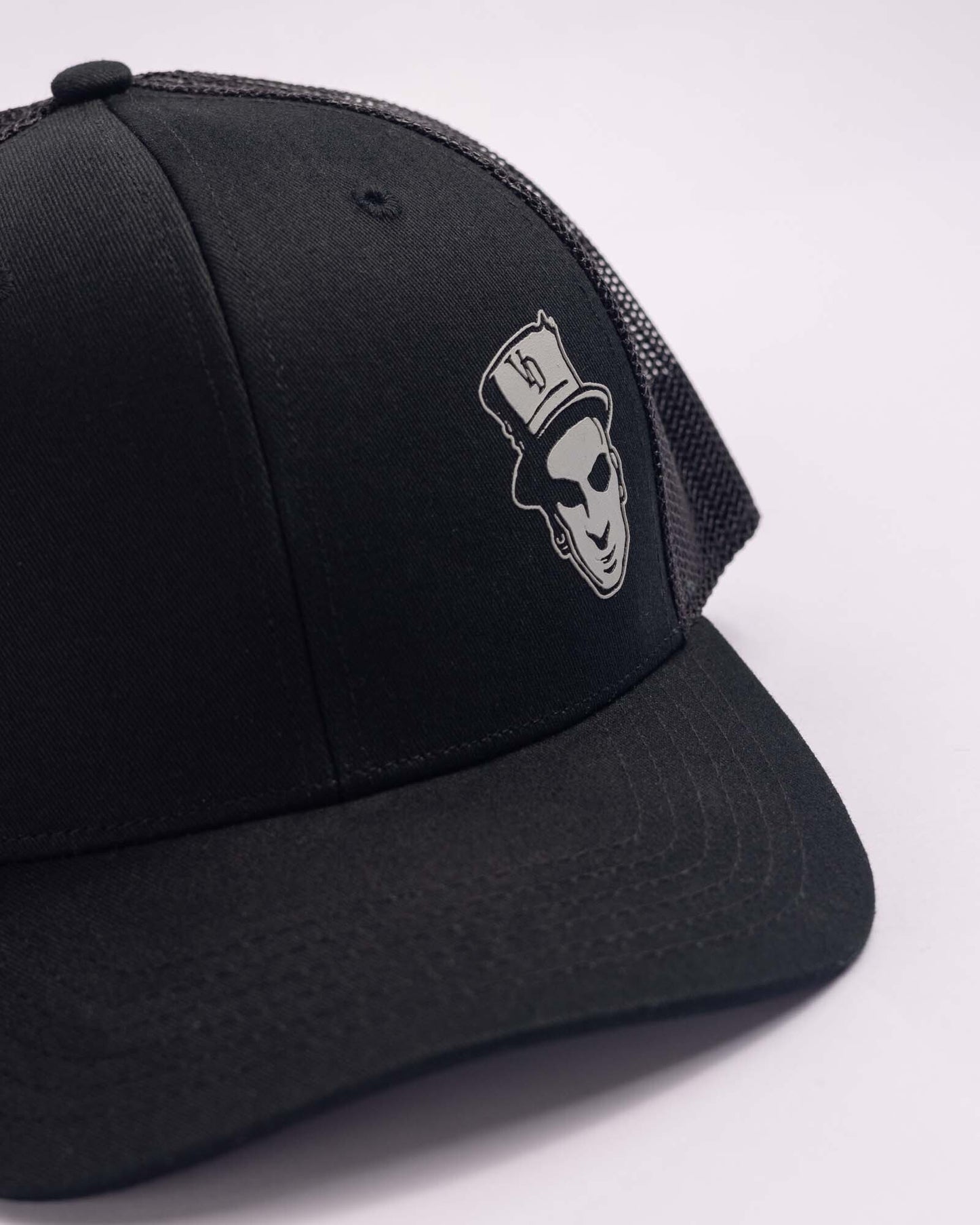 black trucker cap with voodoo baron mark