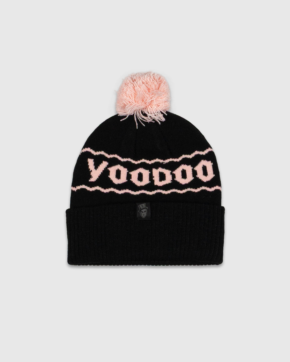 Black beanie with pink pom-pom and 'Voodoo' pattern on a light gray background