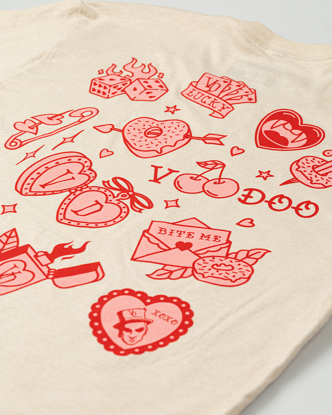 Close up photo of beige t-shirt with red graphic designs