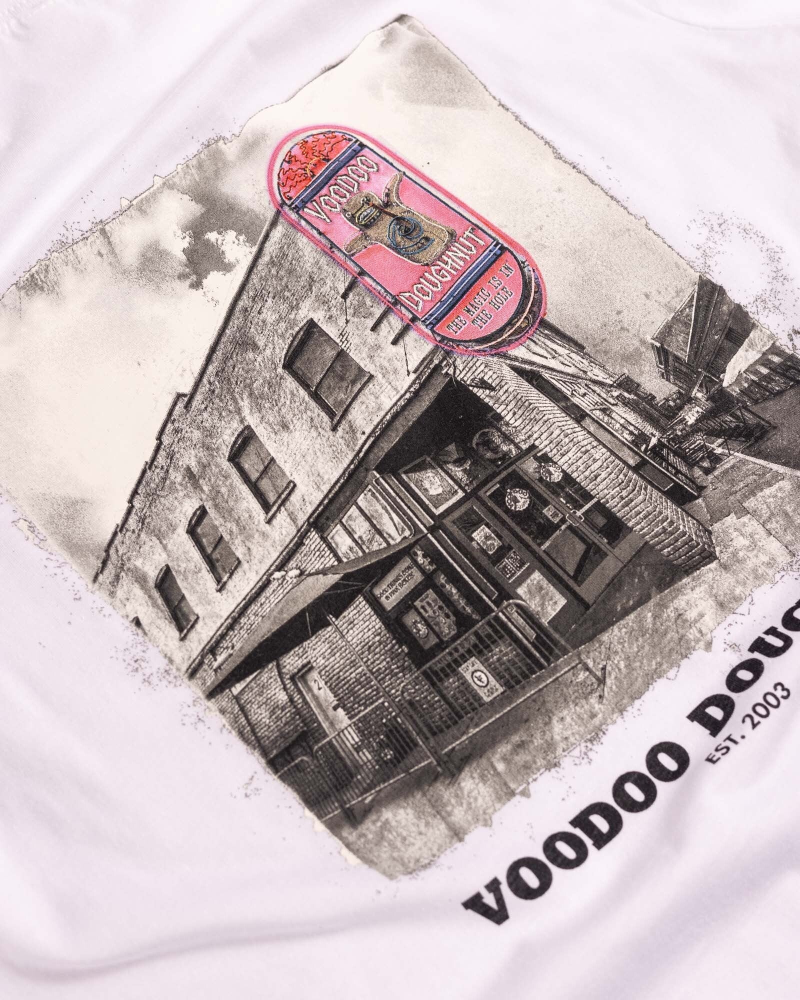 white t-shirt with old town building graphic on center of shirt