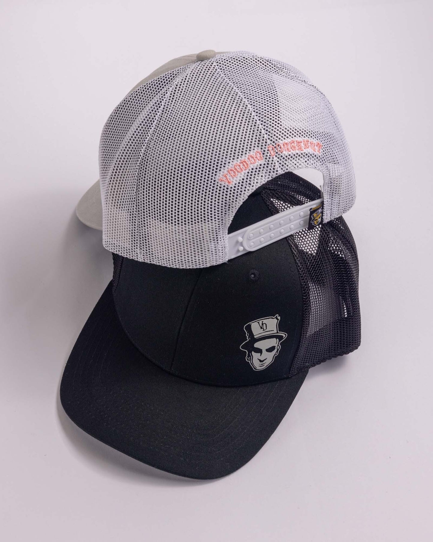 black trucker cap and grey trucker cap